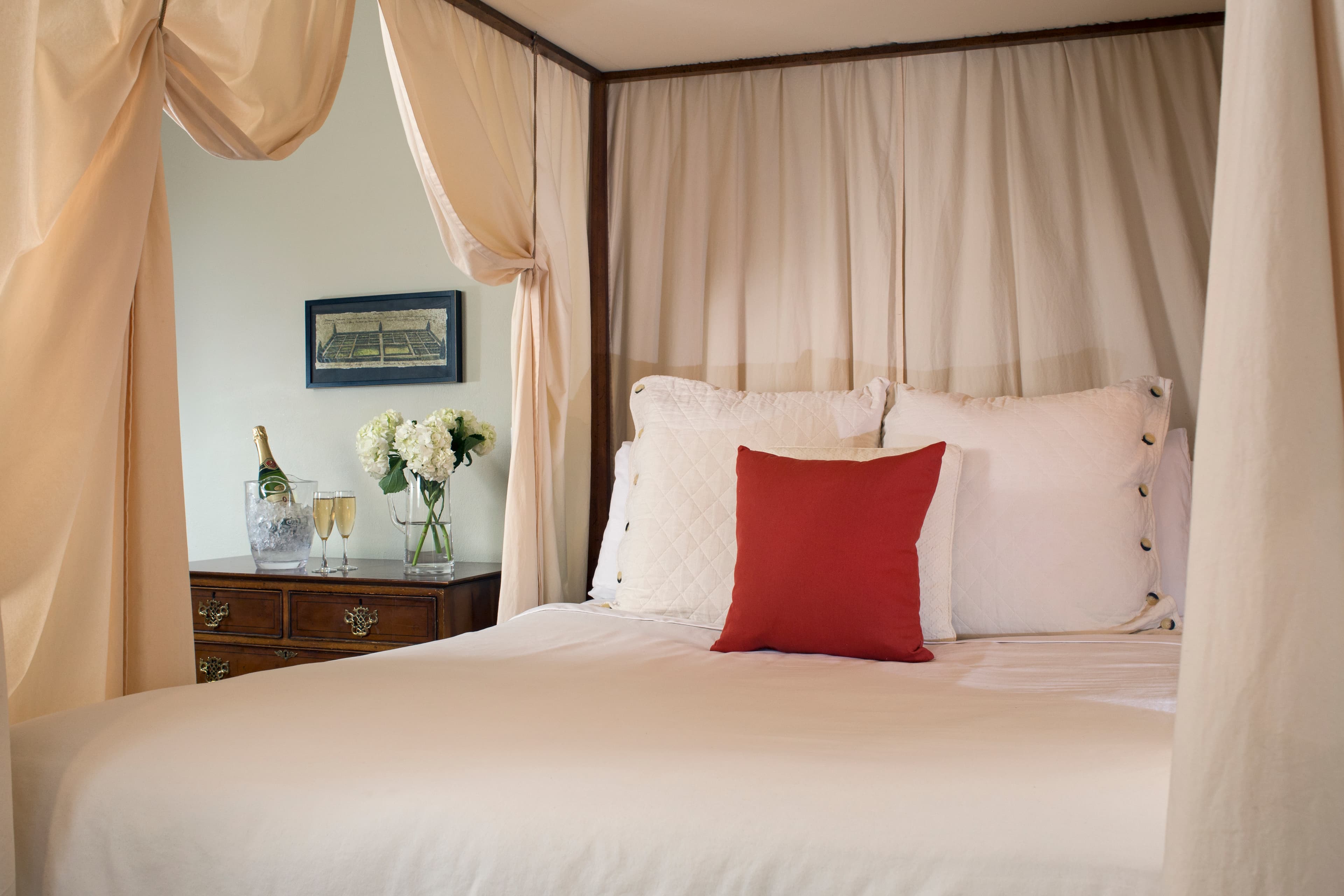 Close up of canopied four-poster bed with decorative pillows