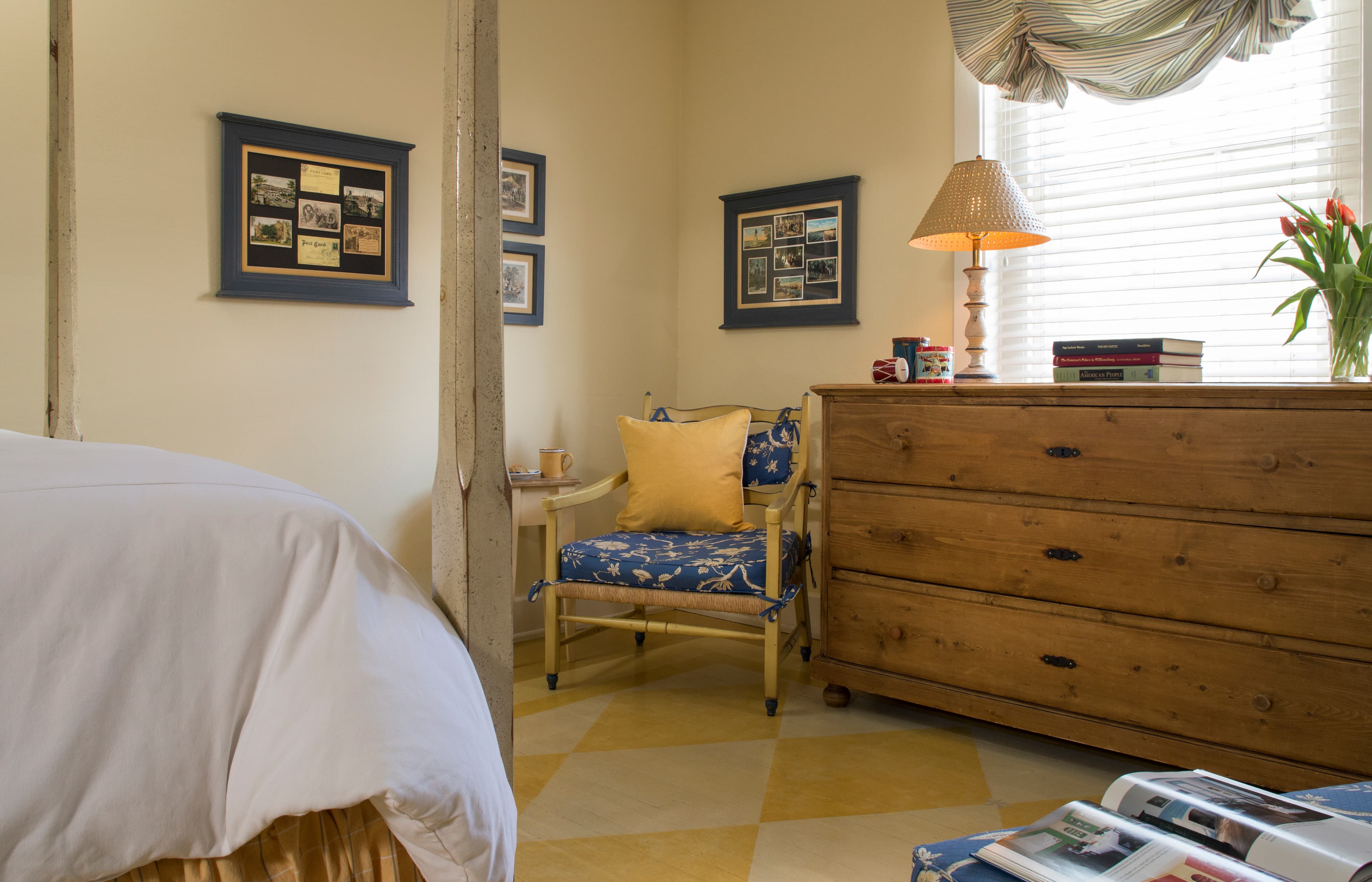 Area opposite bed with wooden chair, large bureau, and sunny window