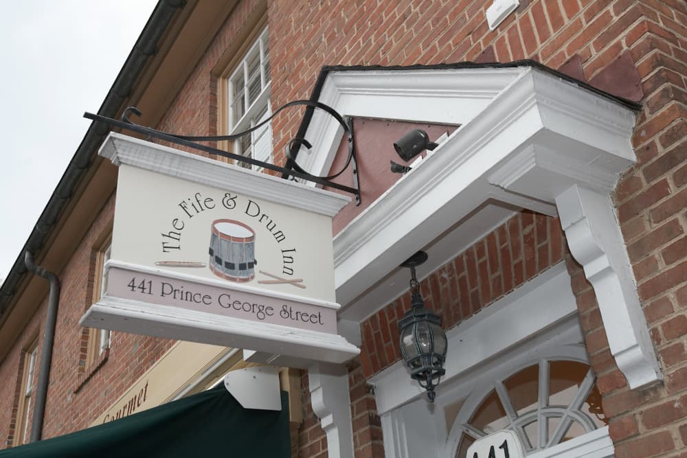 A brick building with a white sign that says Fife and Drum Inn with the address