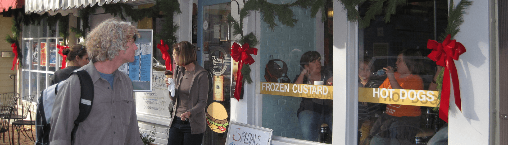 People standing in front of store front with a black and white striped awning