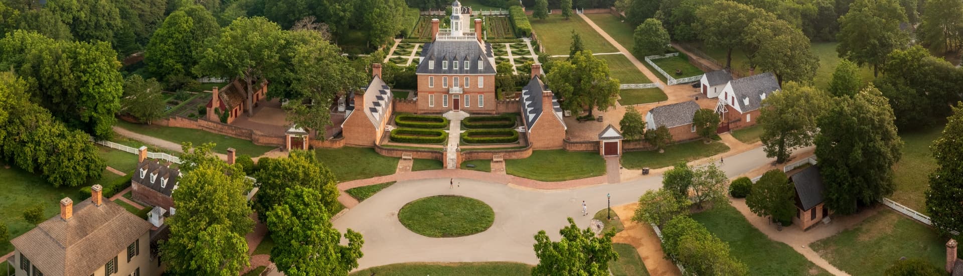 Aerial photo of Governor's palace grounds with Colonial style buildings, with hedge maze a green common areas
